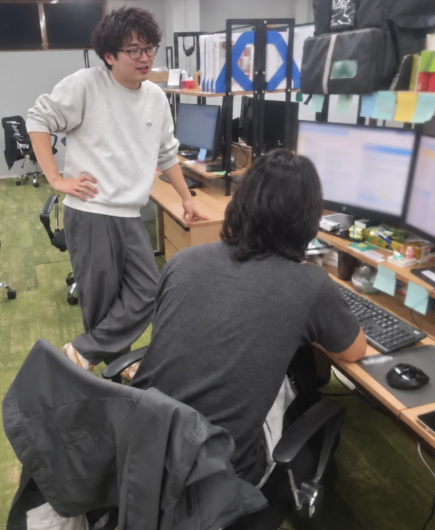 デスクで意見を交わすスタッフ